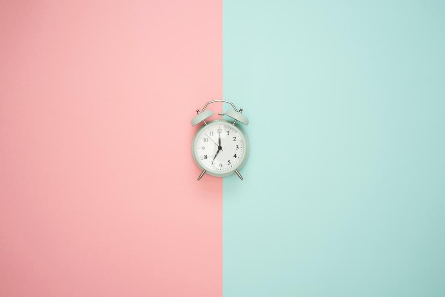 Image of a clock in front of a pink and teal background. Representing the importance of time management coaching in Portland, Salem and anywhere else in Oregon. You can learn strategies to help with time management.