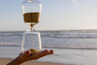 Image of a sand timer in front of the ocean. Showing the importance of learning strategies to help with time management. Time management coaching in Texas, whether that is Dallas, Austin, or Houston, can help you navigate difficulties with time. 