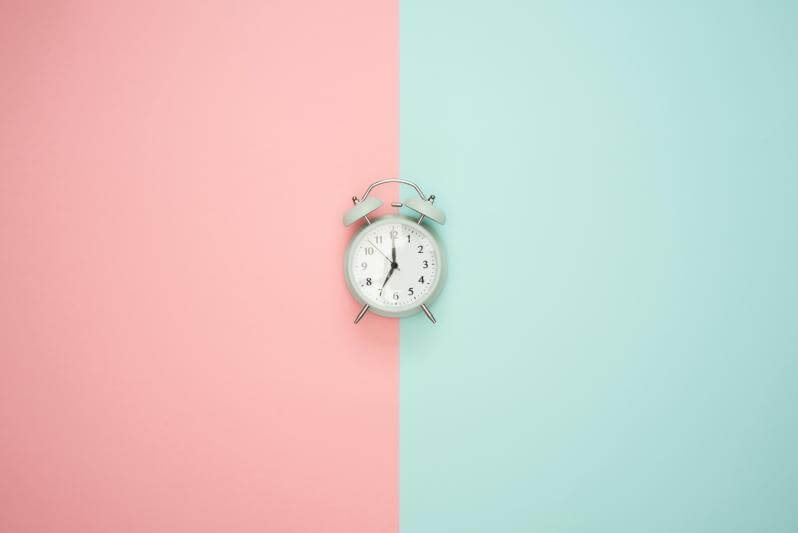 Image of a clock in front of a pink and teal background. Representing the importance of strategies to help with time management in Texas when neurodivergent. Time management coaching can help give you guidance whether you are in Houston, Dallas, Austin, or anywhere in Texas.