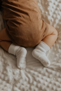 Image of a baby in a brown onesie. Representing a major life change that life coaching can help with in Houston, Dallas, & around Texas. A lif coach can support you in making decisions.