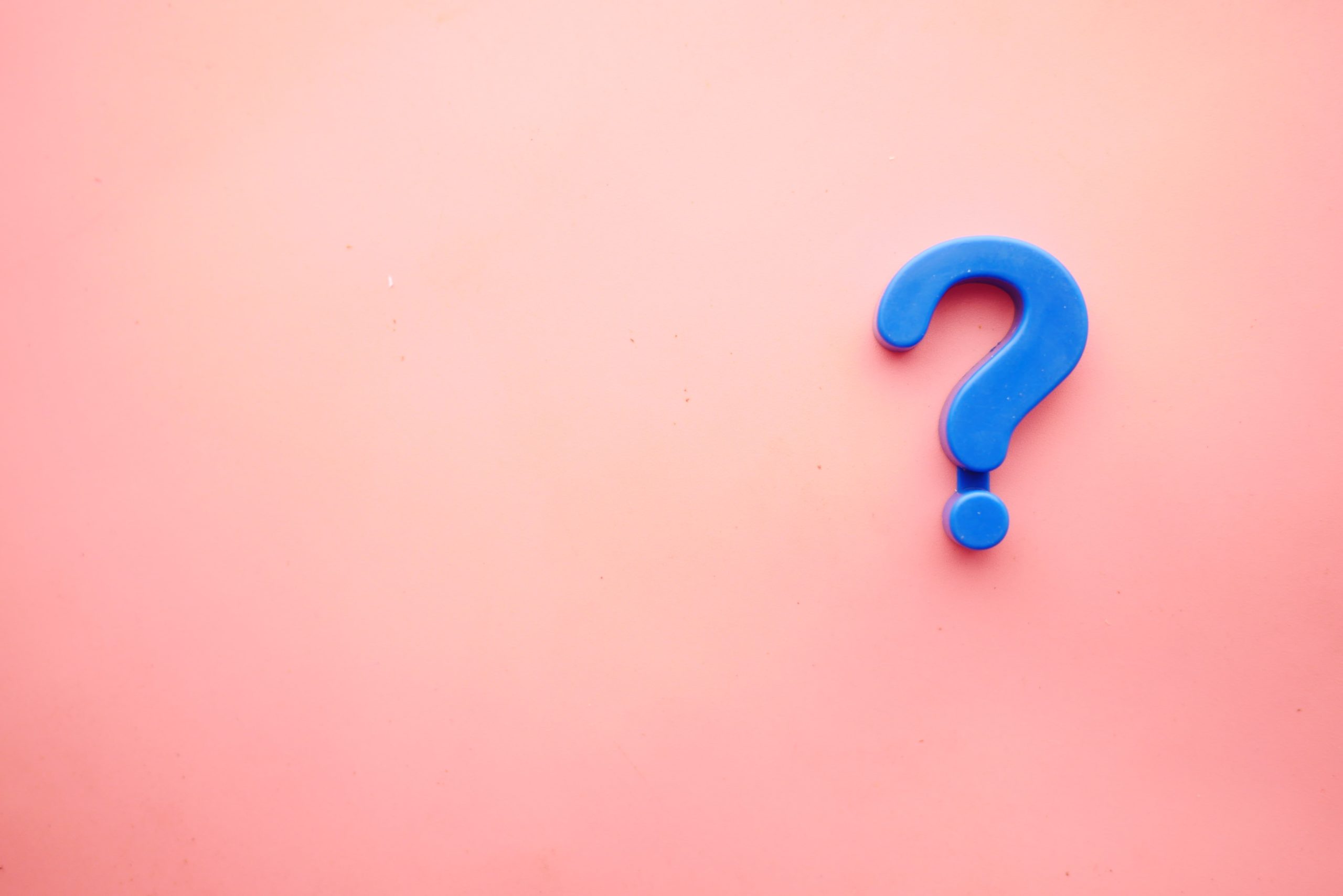 Image of a blue question mark in front of a pink background. Representing that life coaching can be used for support in making changes. A life coach can help you find strategies that work for you.
